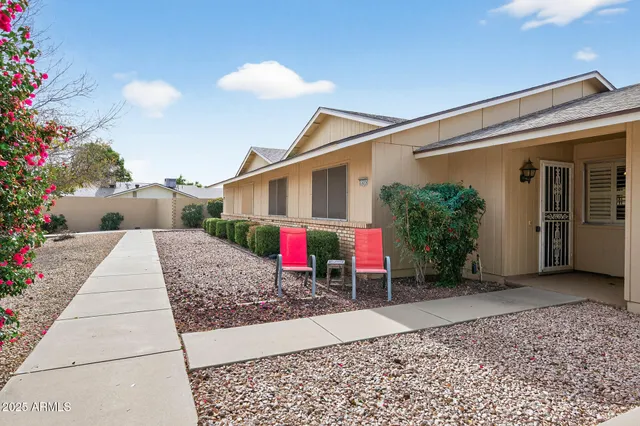 a view of a house with a small yard and potted plants