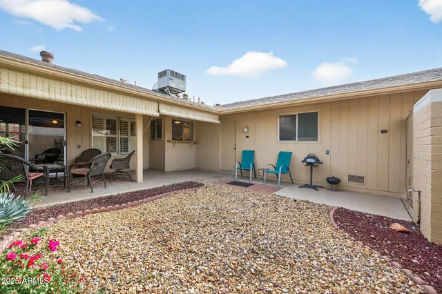 a backyard of a house with table and chairs