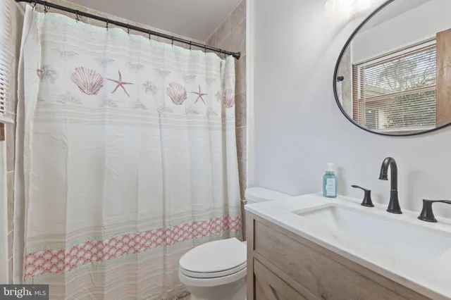 a bathroom with a toilet a sink and a mirror