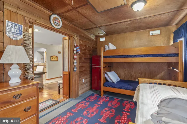 a bedroom with a bed and a lamp on the dresser