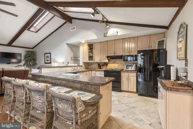 a kitchen with stainless steel appliances granite countertop a sink a stove and a refrigerator