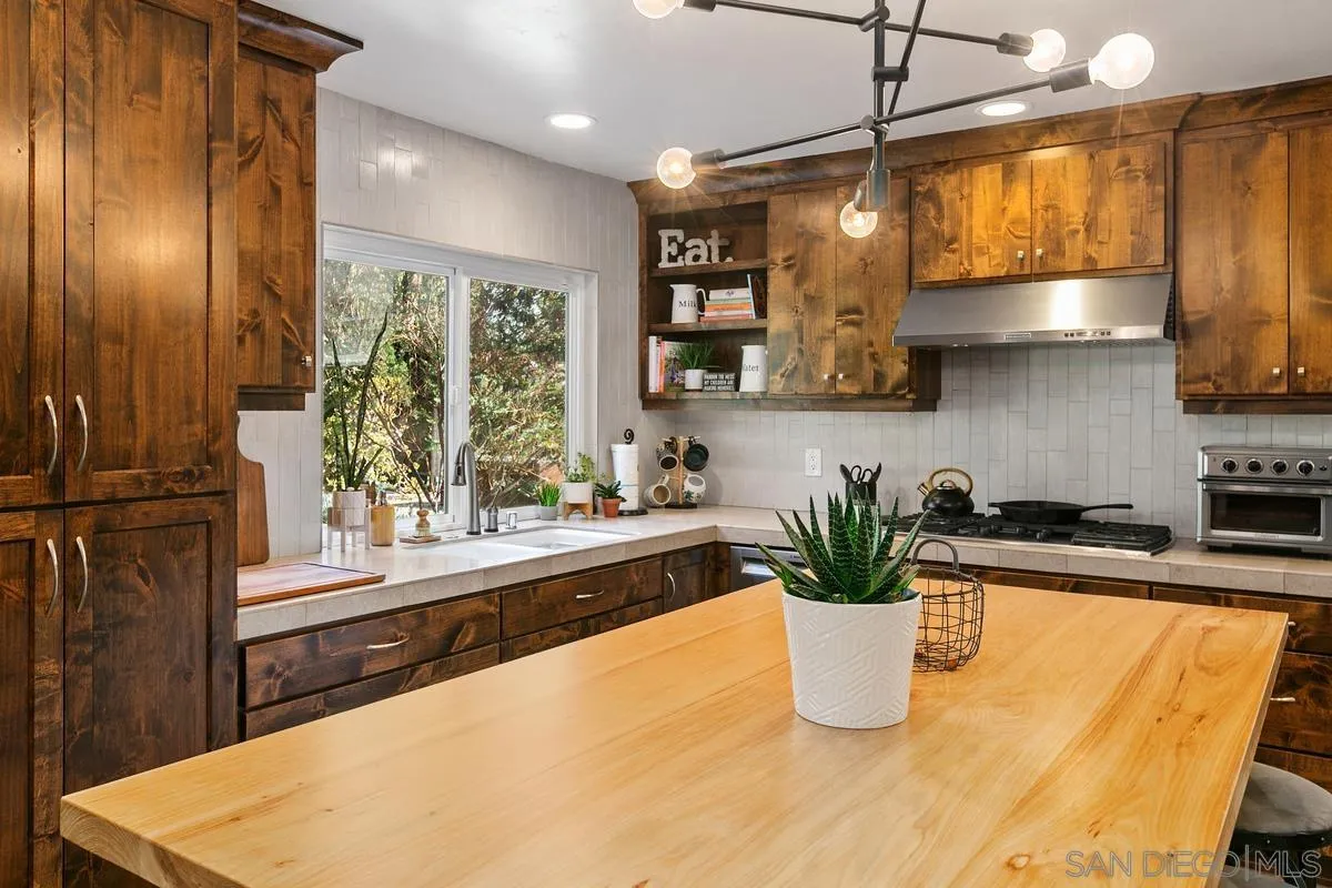 2815 Jacaranda Avenue Carlsbad, CA 92009 - Photo 14 of 30 a kitchen with stainless steel appliances granite countertop a refrigerator a sink a stove and a wooden floors