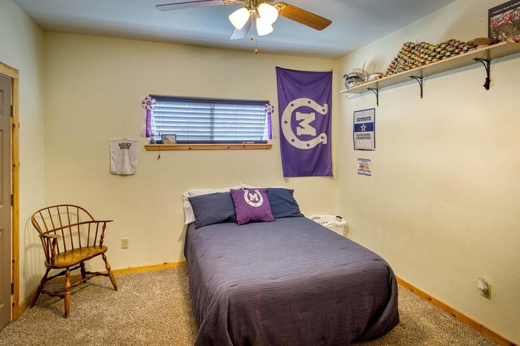 6446 Blackjack Road Fredonia, TX 76842 - Photo 35 of 48 a bedroom with a bed and a chandelier