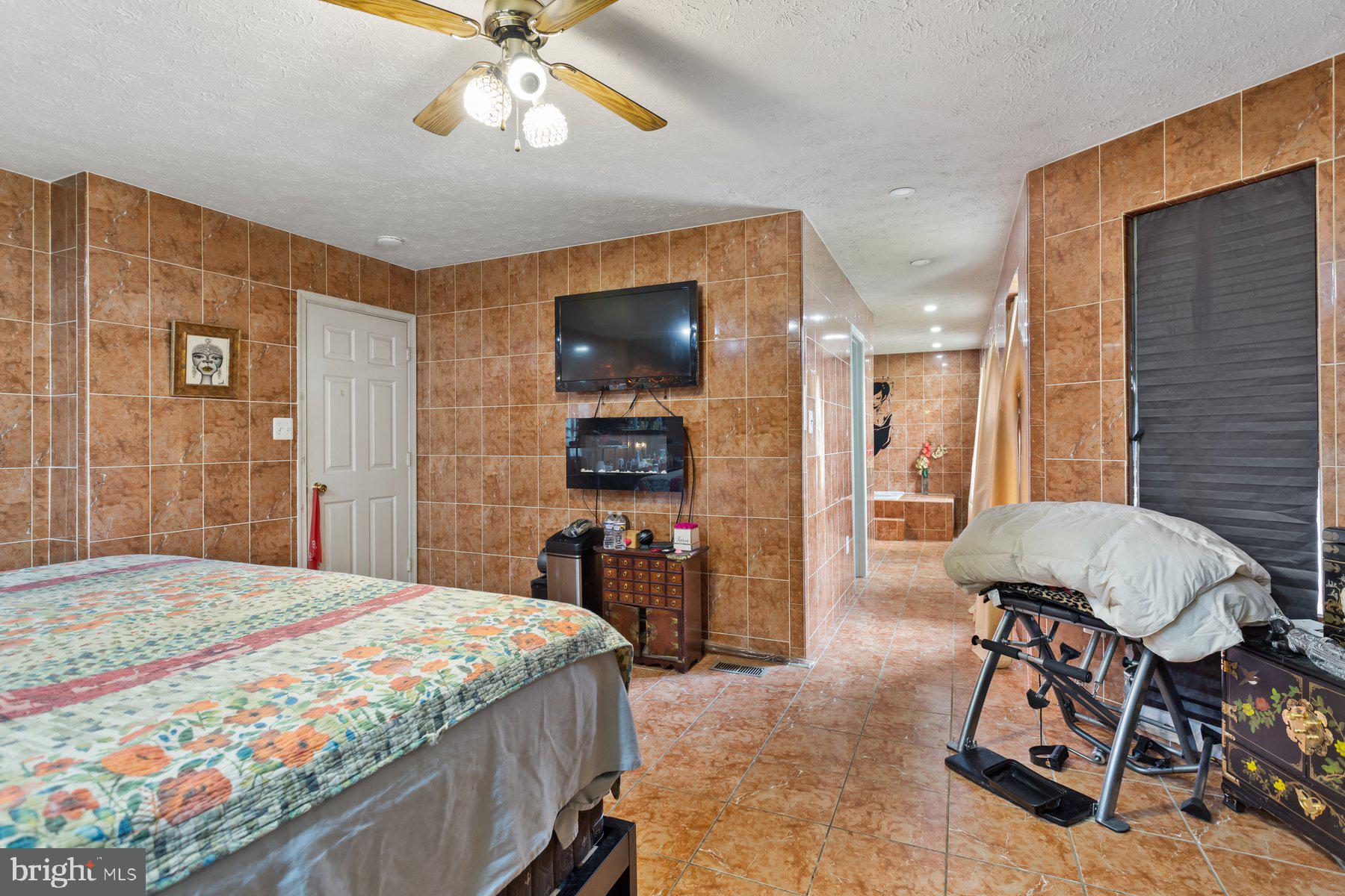 2448 Shellcove Court Waldorf, MD 20601 - Photo 33 of 38 a spacious bedroom with a bed a chandelier and a flat screen tv