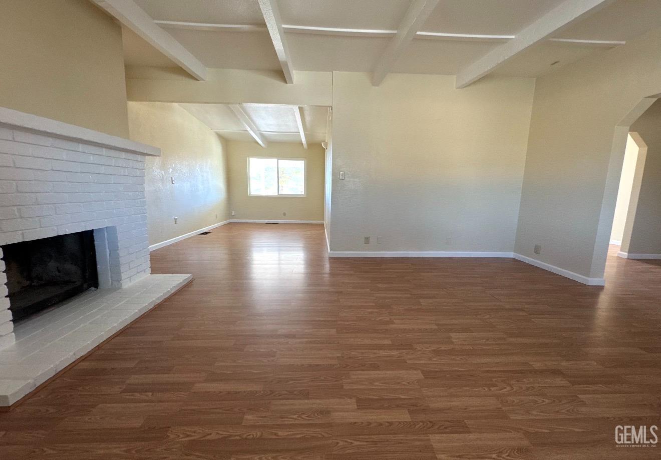 Undisclosed Address Ridgecrest, CA 93555 - Photo 11 of 45 a view of empty room with wooden floor and fireplace