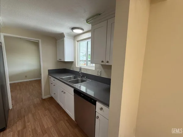 a kitchen with wooden floors and white appliances