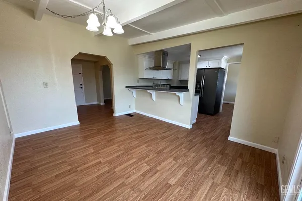 a view of kitchen with stainless steel appliances granite countertop a refrigerator a stove top oven a sink and dishwasher with wooden floor