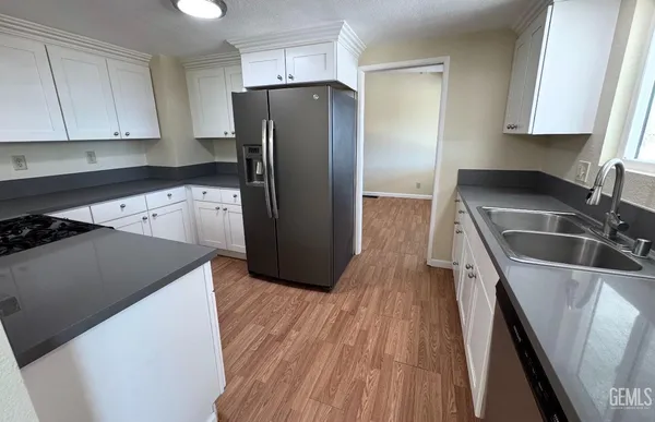 a kitchen with a refrigerator sink and cabinets