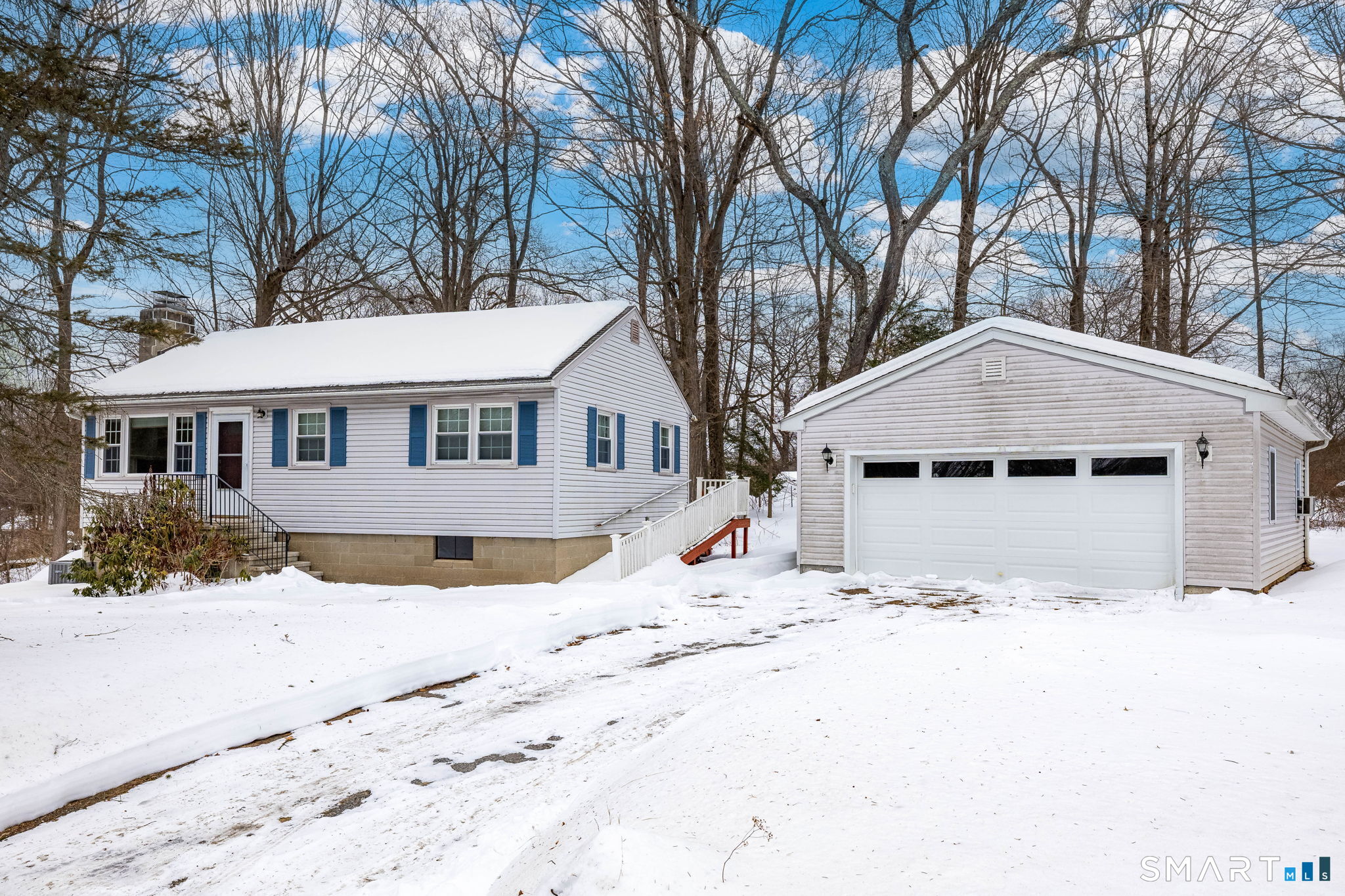 a front view of a house with a yard covered in snow