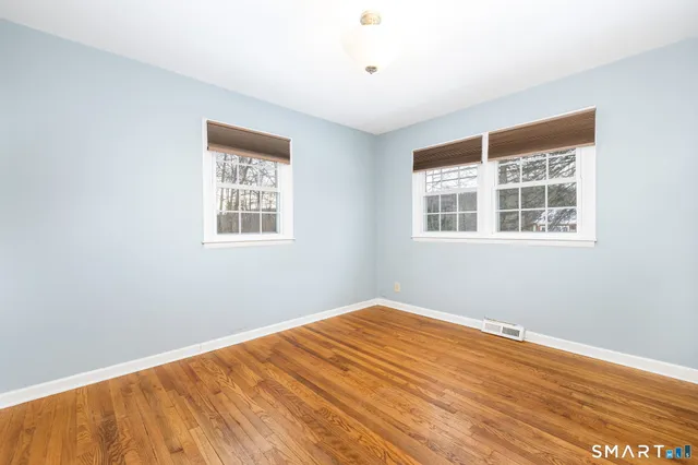 a view of a big room with wooden floor and windows