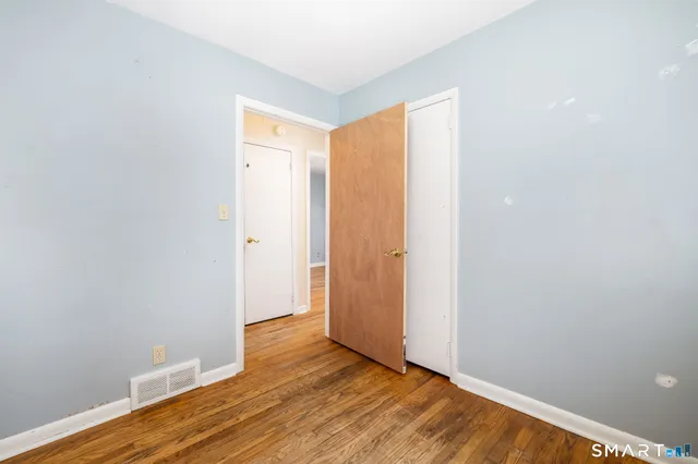 a view of an empty room with wooden floor