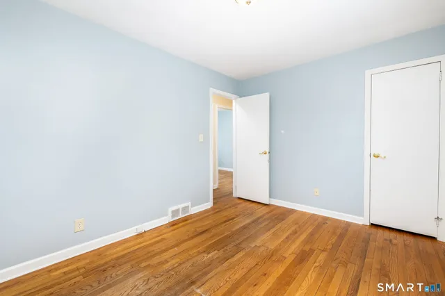 a view of an empty room with wooden floor