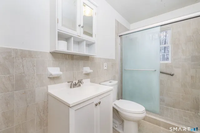 a bathroom with a sink a toilet and shower