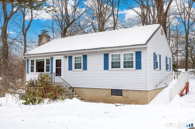 a view of a house with a yard covered in snow