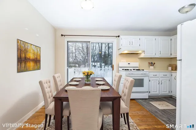 a dining room with stainless steel appliances a table and chairs