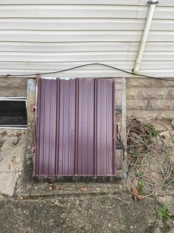 a view of a backyard with large trees and wooden fence