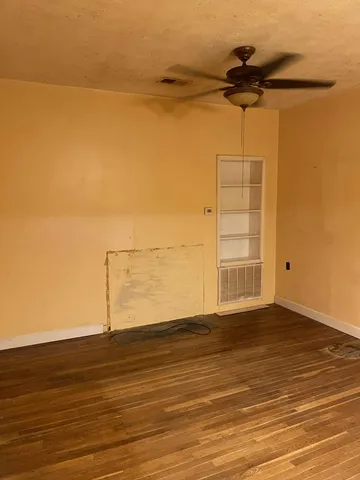 a view of a room with wooden floor and a window