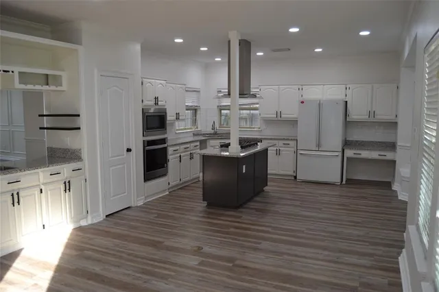 a kitchen with stainless steel appliances granite countertop a refrigerator and a stove top oven