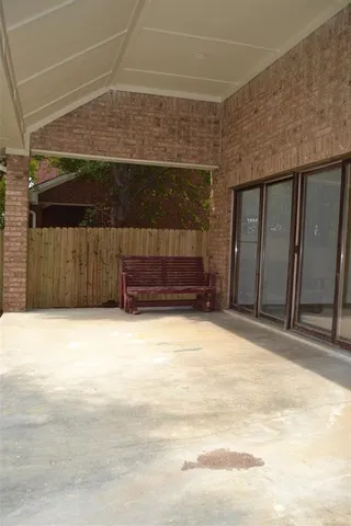 a view of a backyard with a large tree and wooden fence