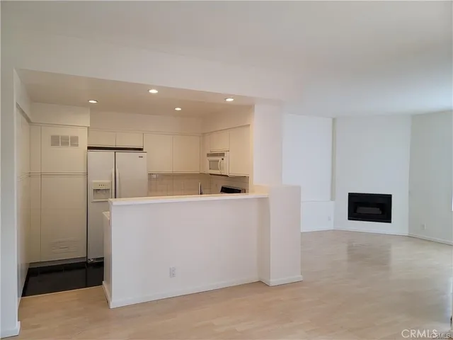 a living room with stainless steel appliances kitchen island a table and a couch