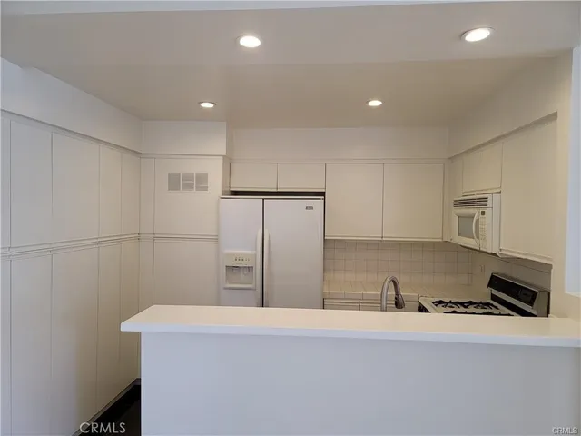 a kitchen with stainless steel appliances a refrigerator and a stove