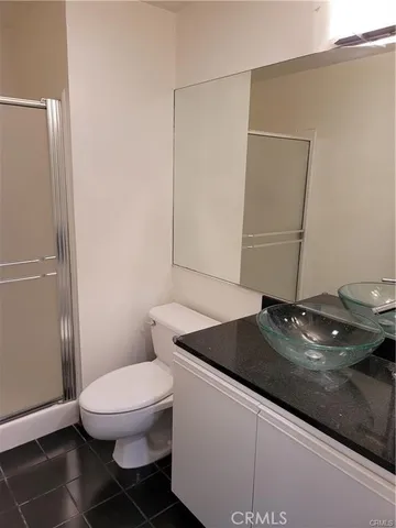 a bathroom with a granite countertop sink and a toilet