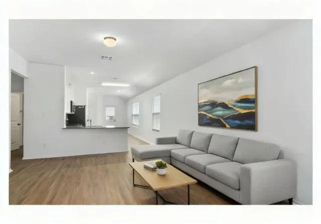 a living room with furniture and a wooden floor