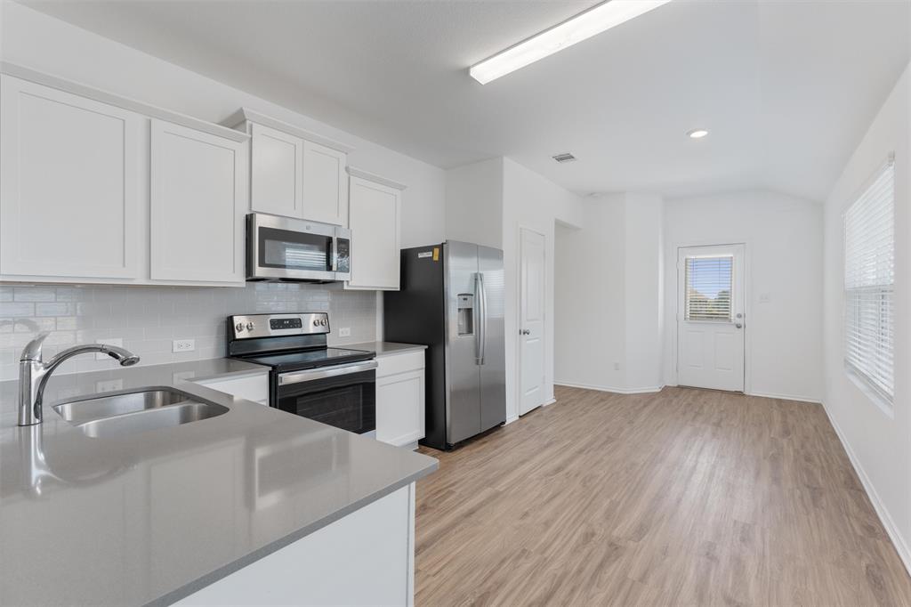 108 Joe Kidd Lane Jarrell, TX 76537 - Photo 12 of 22 a kitchen with wooden cabinets and stainless steel appliances