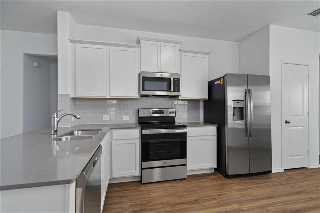 108 Joe Kidd Lane Jarrell, TX 76537 - Photo 4 of 22 a kitchen with a sink stove and refrigerator
