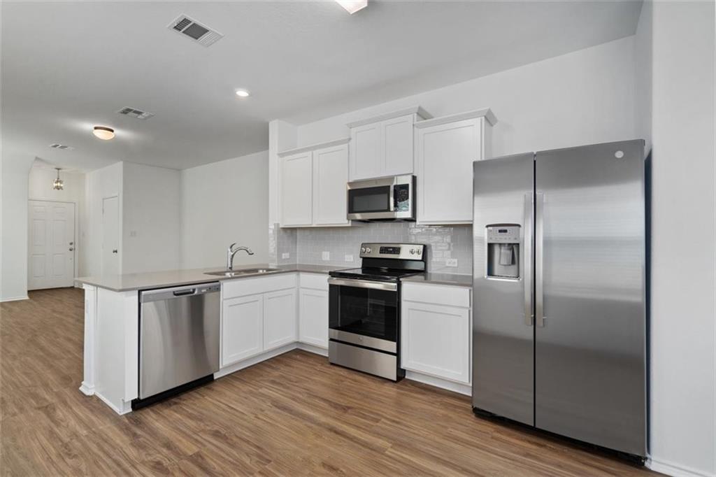 108 Joe Kidd Lane Jarrell, TX 76537 - Photo 5 of 22 a kitchen with a refrigerator sink and microwave