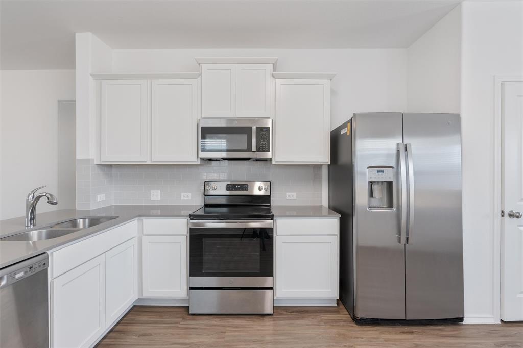108 Joe Kidd Lane Jarrell, TX 76537 - Photo 7 of 22 a kitchen with white cabinets and stainless steel appliances