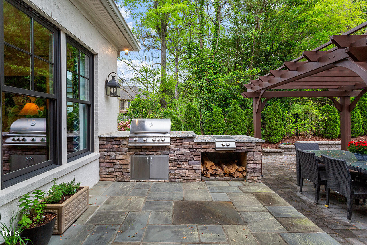 2311 Churchill Road Raleigh, NC 27608 - Photo 17 of 73 a view of a patio with table and chairs potted plants with wooden floor