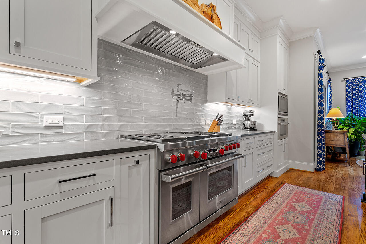 2311 Churchill Road Raleigh, NC 27608 - Photo 27 of 73 a kitchen with stainless steel appliances granite countertop a stove and a sink