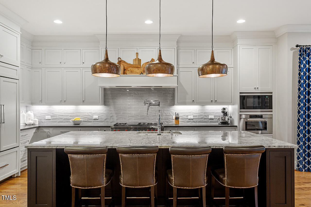 2311 Churchill Road Raleigh, NC 27608 - Photo 28 of 73 a kitchen with stainless steel appliances granite countertop a stove a sink and white cabinets