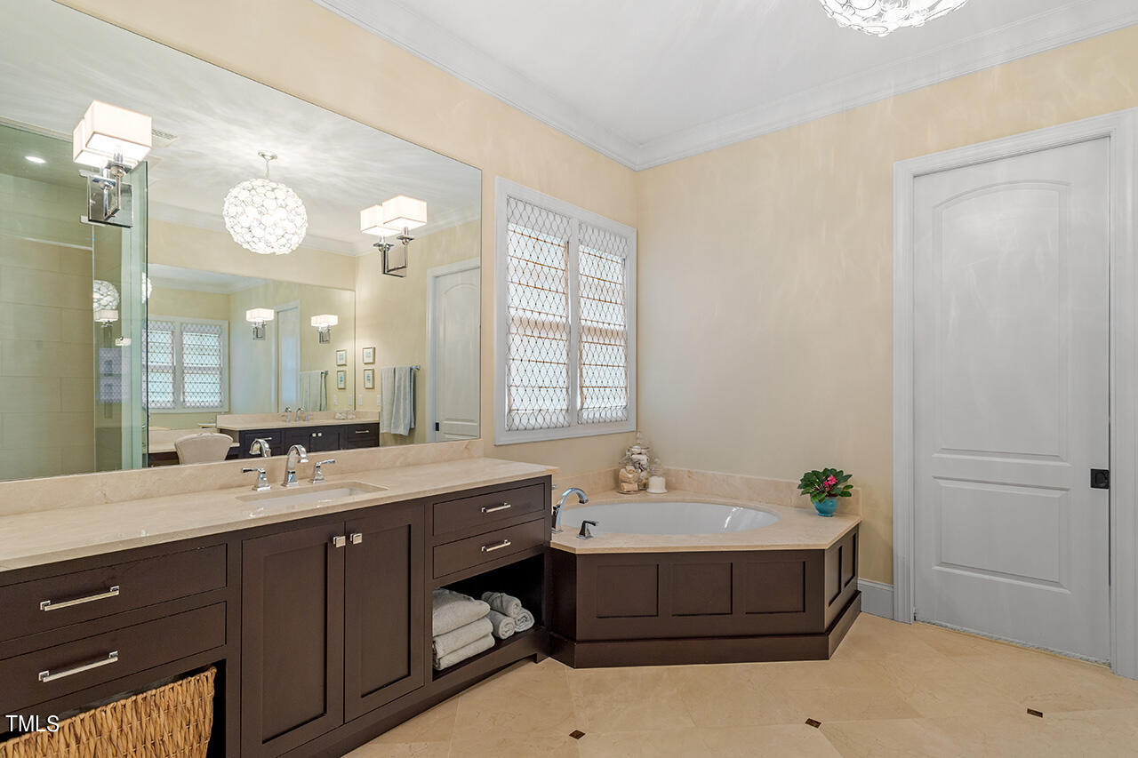 2311 Churchill Road Raleigh, NC 27608 - Photo 40 of 73 a bathroom with a double vanity sink a mirror and a bathtub