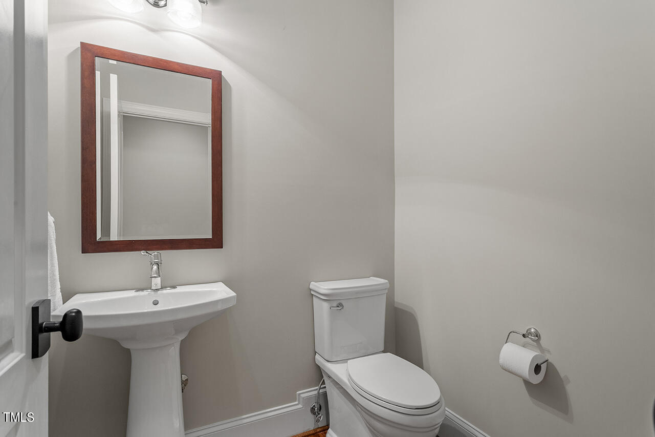 2311 Churchill Road Raleigh, NC 27608 - Photo 52 of 73 a bathroom with a toilet sink and mirror