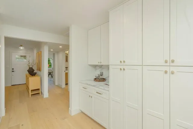 a hallway with white cabinets