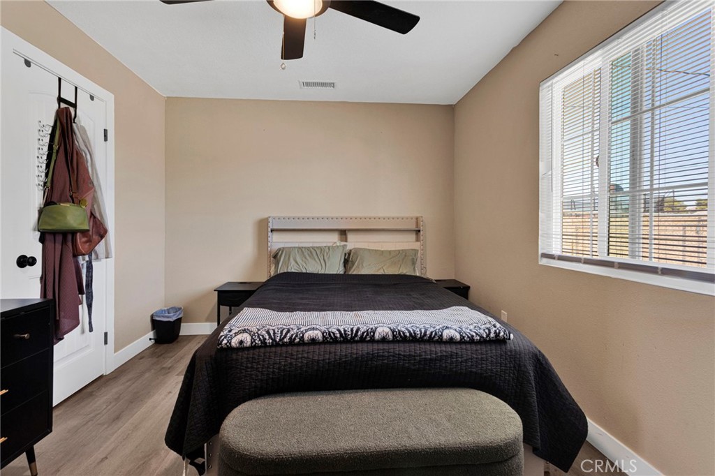 15471 Washoan Road Apple Valley, CA 92307 - Photo 17 of 38 a bedroom with a bed window and a chandelier