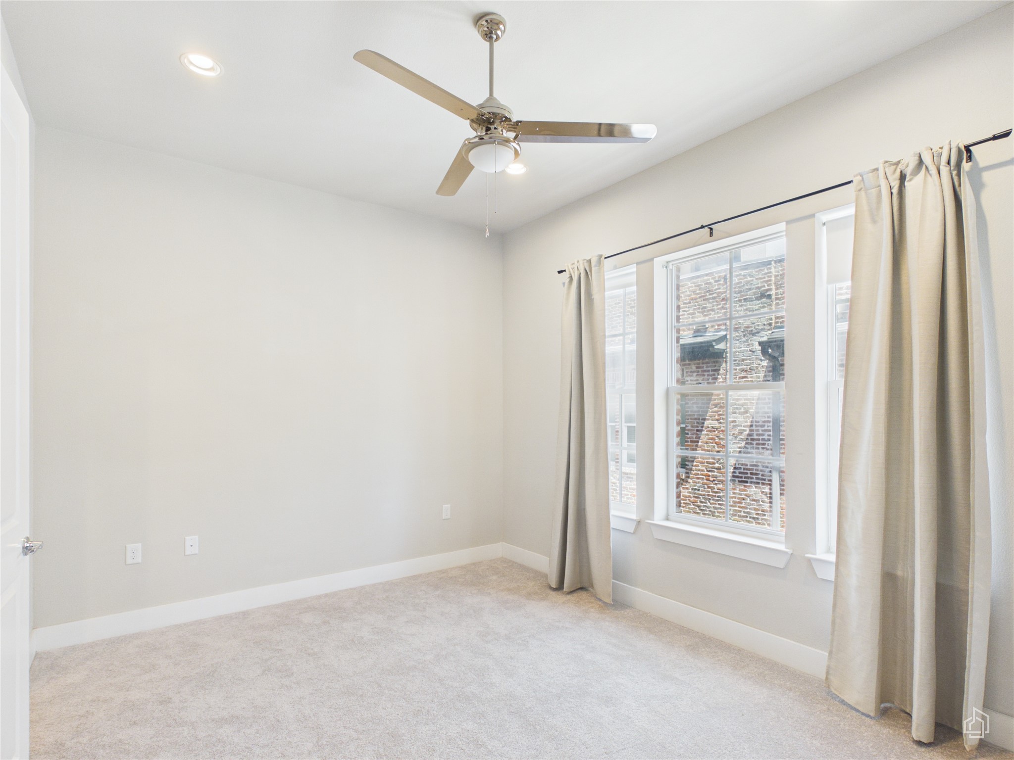 1308 Tinnin Ford Road, Unit 14 Austin, TX 78741 - Photo 18 of 40 High ceilings and tall windows enhance this carpeted bedroom.