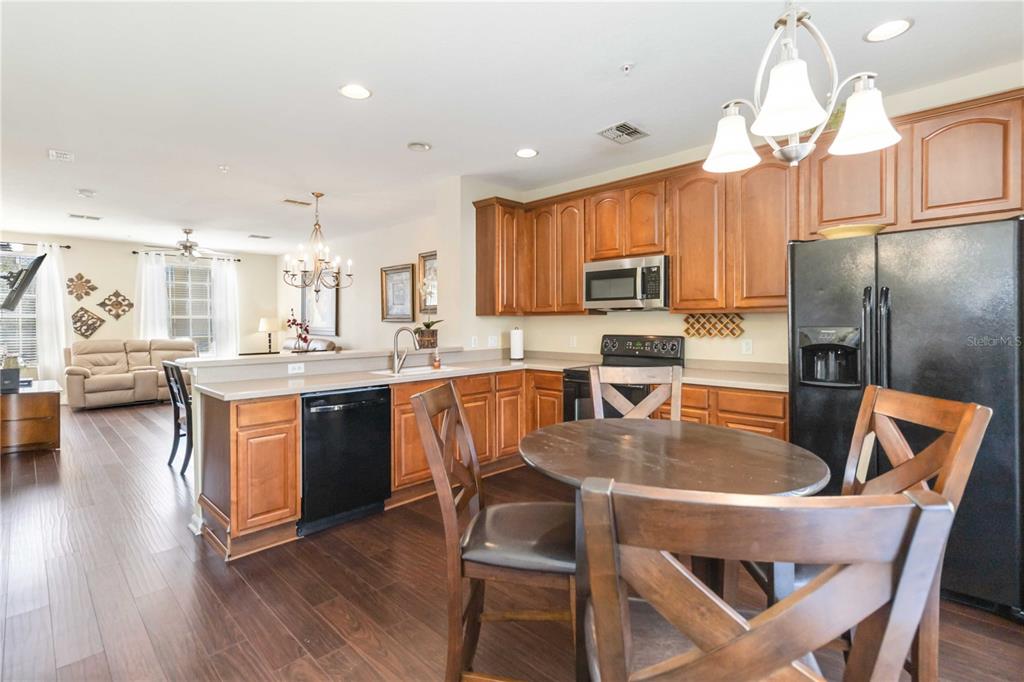 5038 Tideview Circle, Unit 26 Orlando, FL 32819 - Photo 9 of 42 a kitchen with stainless steel appliances granite countertop a refrigerator a stove top oven a sink dishwasher and white cabinets with wooden floor