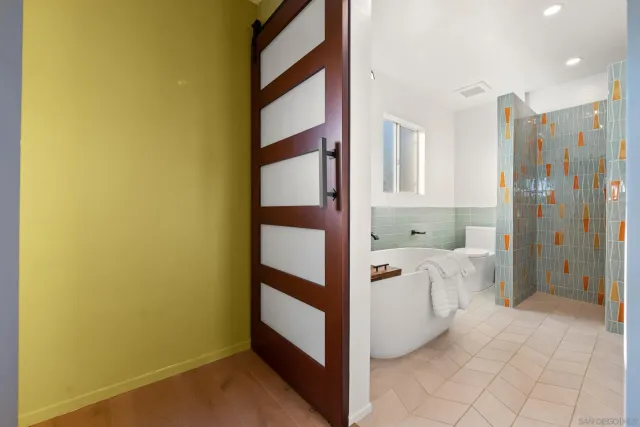 a kitchen with stainless steel appliances wooden floor and staircase