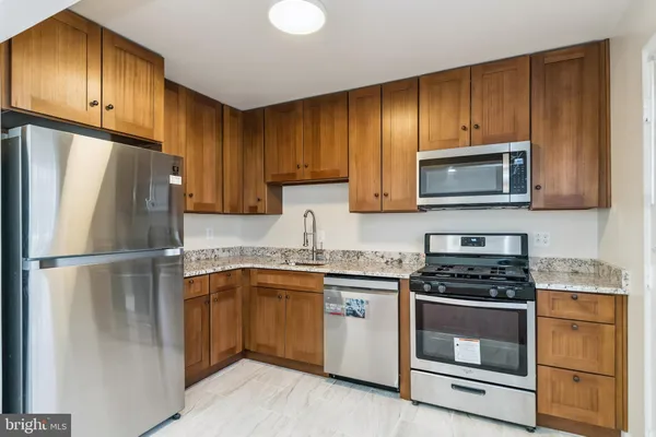 a kitchen with a sink a microwave a refrigerator and cabinets