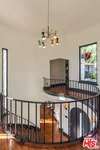 a spacious bedroom with a bed a couch and large window