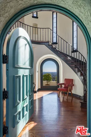 a view of livingroom with furniture wooden floor windows and a kitchen view