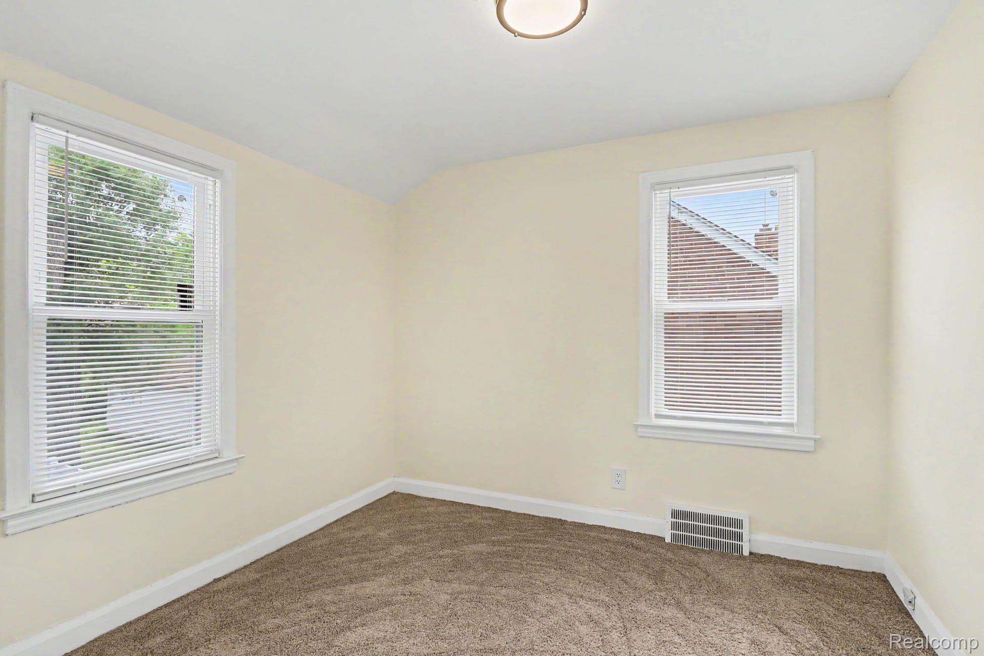 16682 Robson Street Detroit, MI 48235 - Photo 15 of 19 Neutral wall color with two windows featuring white blinds, brown carpeting, and a flush-mount ceiling light fixture