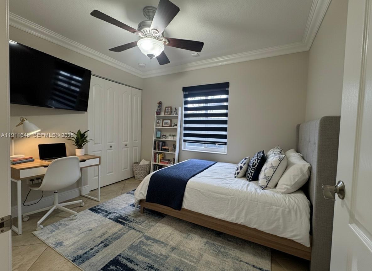 6905 Southwest 148th Court Miami, FL 33193 - Photo 24 of 26 a bedroom with a bed a couch and a flat screen tv