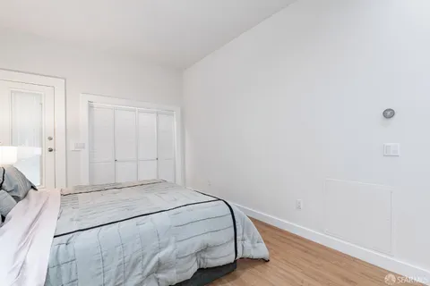 a room with a bed and wooden floor