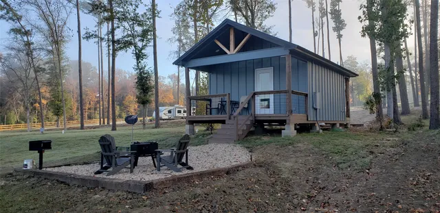 a view of house with backyard and outdoor seating