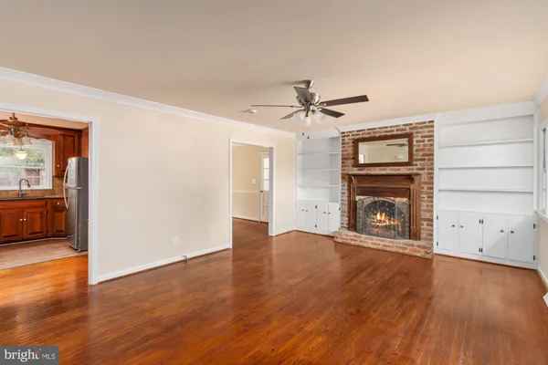 a kitchen with stainless steel appliances granite countertop a refrigerator a sink dishwasher a stove and a dining table with wooden floor