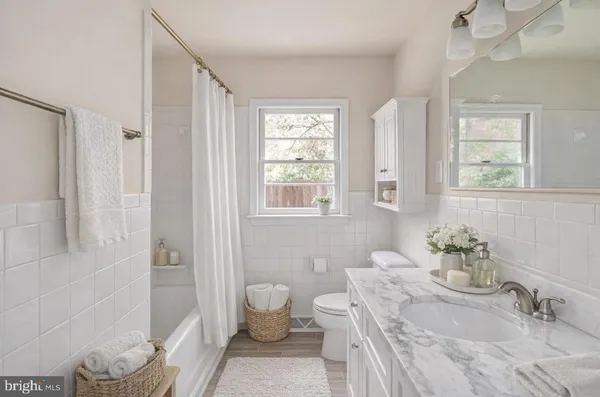 an empty room with wooden floor fireplace and windows